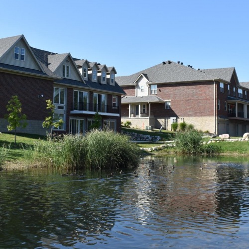 Settle into comfort at Townhomes of Caswell a row of houses next to a river